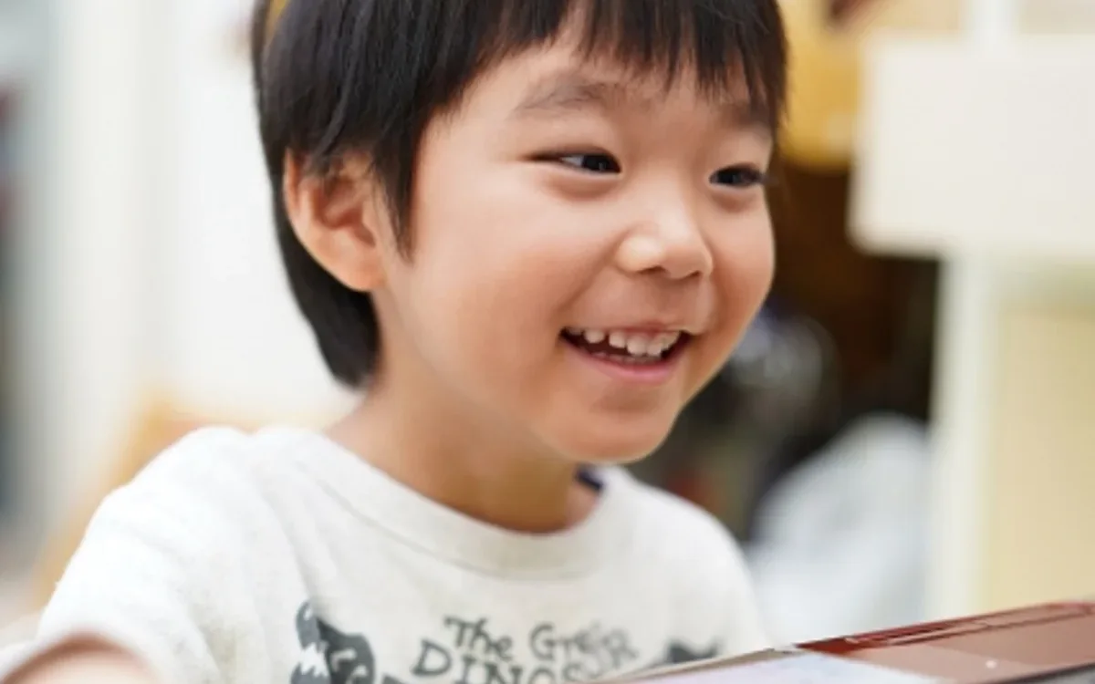 パソコンの前で笑顔の子ども